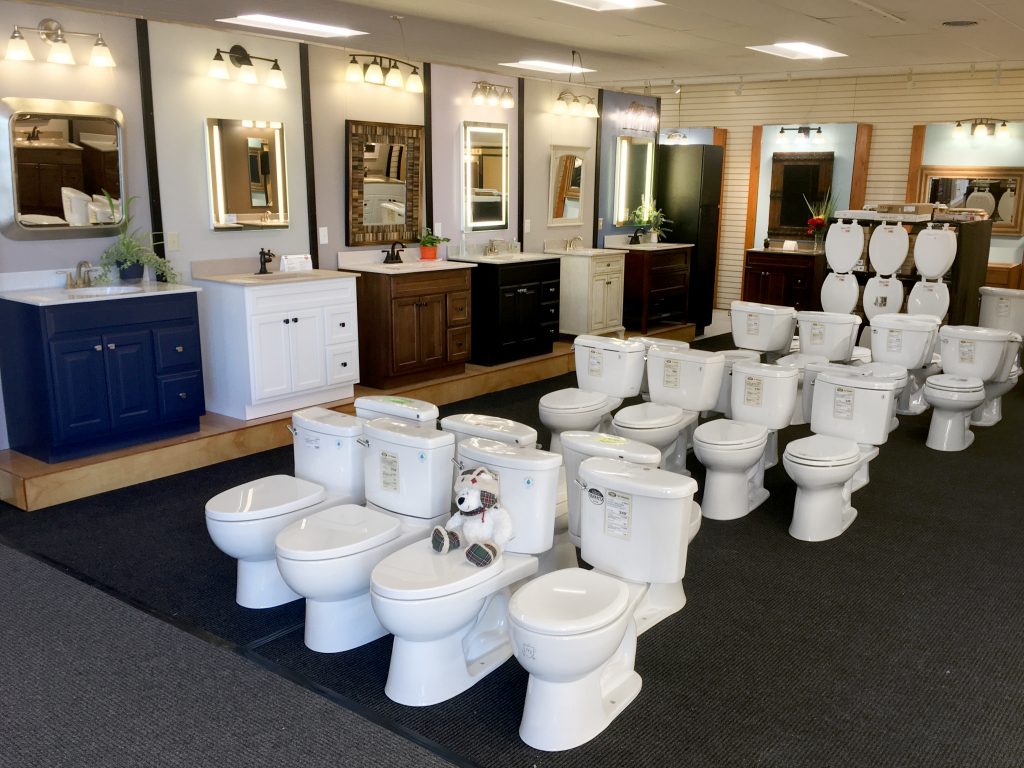 Wide showroom image with toilets, vanities, lights, and mirrors.